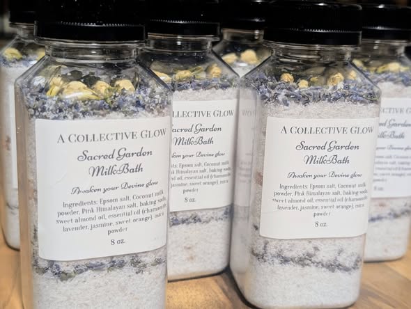 A Collective Glow Sacred Garden milk bath bottles layered with botanicals